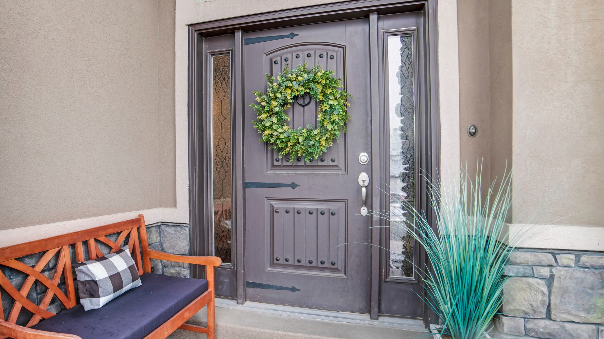 Brown exterior door with fresh green wreath on it