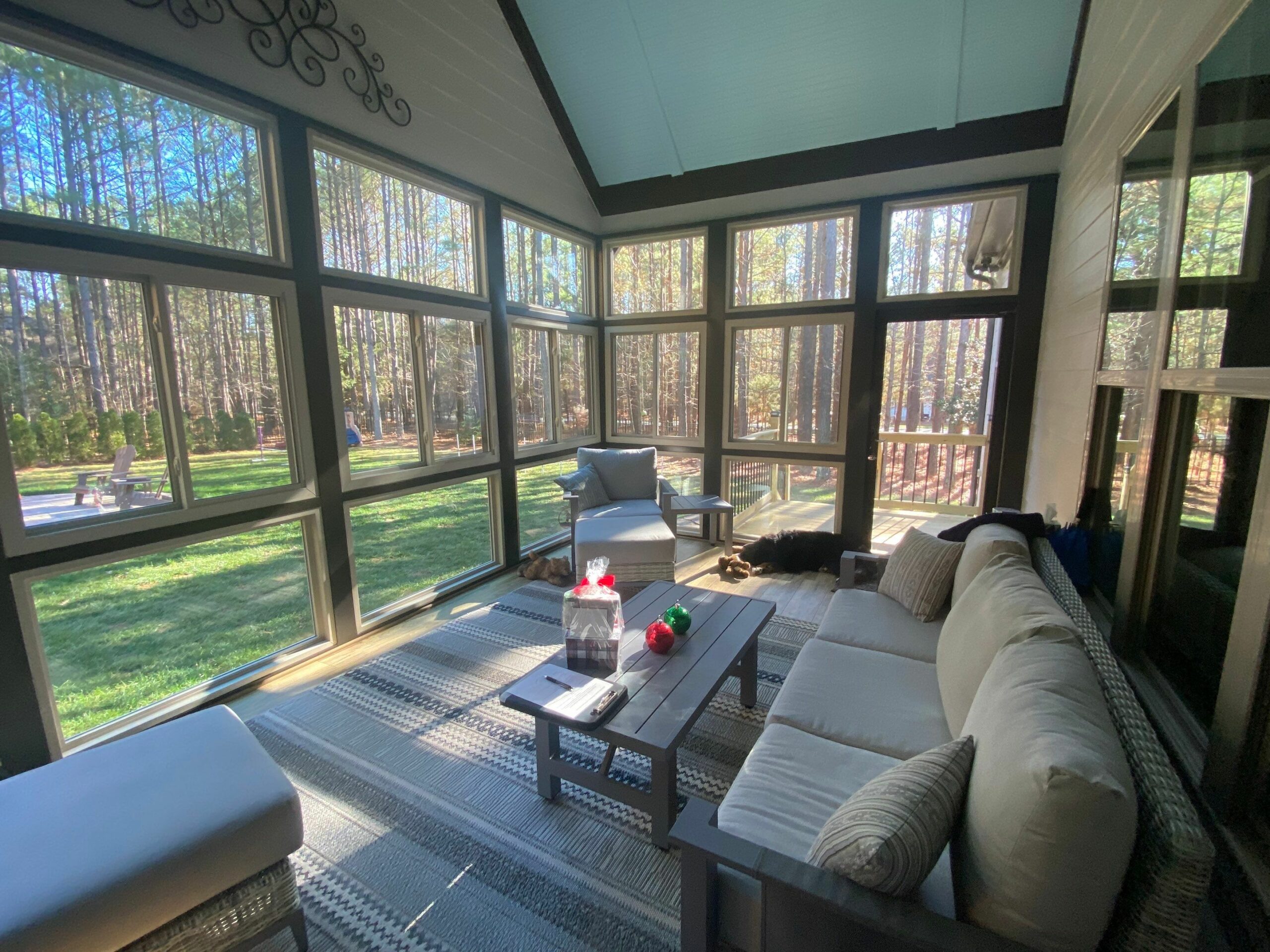 Exterior of a pink home with a sunroom and windows open