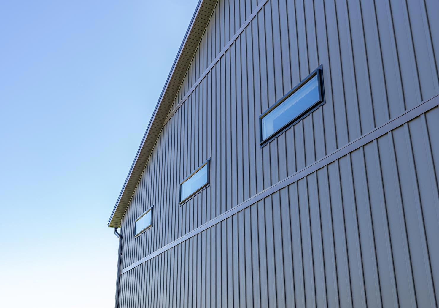 Side of a building with brown siding and small, horizontal windows