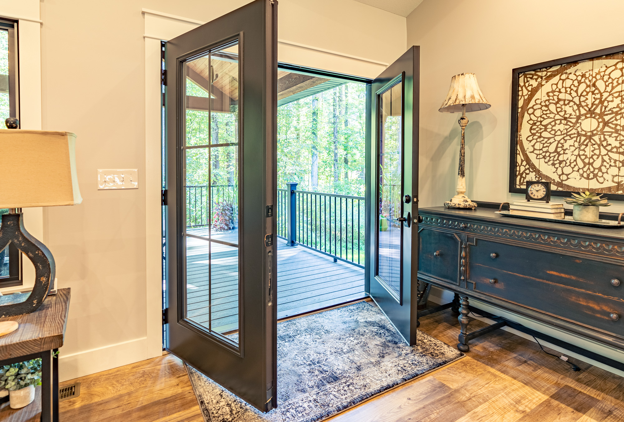 Opened French patio doors leading out to the back deck of a house